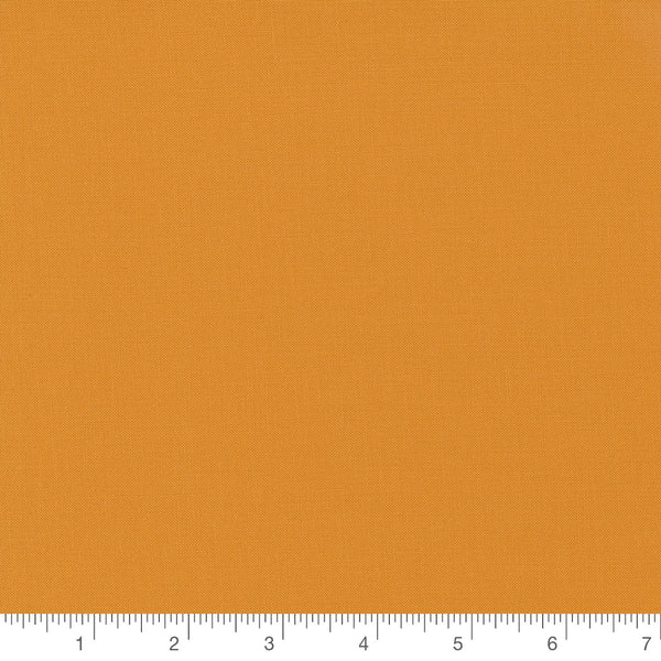 Bella Solid in Cheddar Orange by Moda, solid cheddar orange quilting cotton fabric swatch with inch ruler for scale