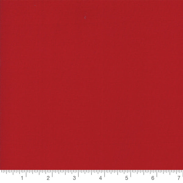 Country Red Bella Solid by Moda, solid quilting cotton with a ruler for scale