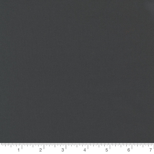 Bella Solids in Charcoal by Moda, dark charcoal grey solid quilting cotton with a ruler for scale